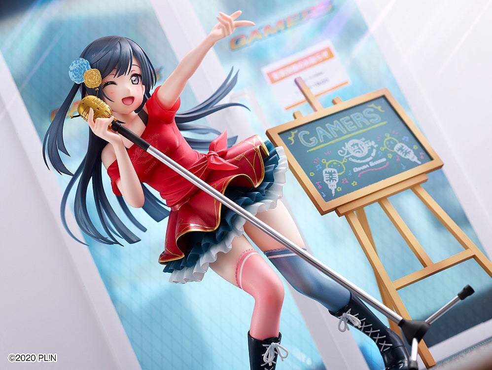 Anime figure of a winking girl in a red idol costume, singing into a golden microphone, beside a "GAMERS" chalkboard.