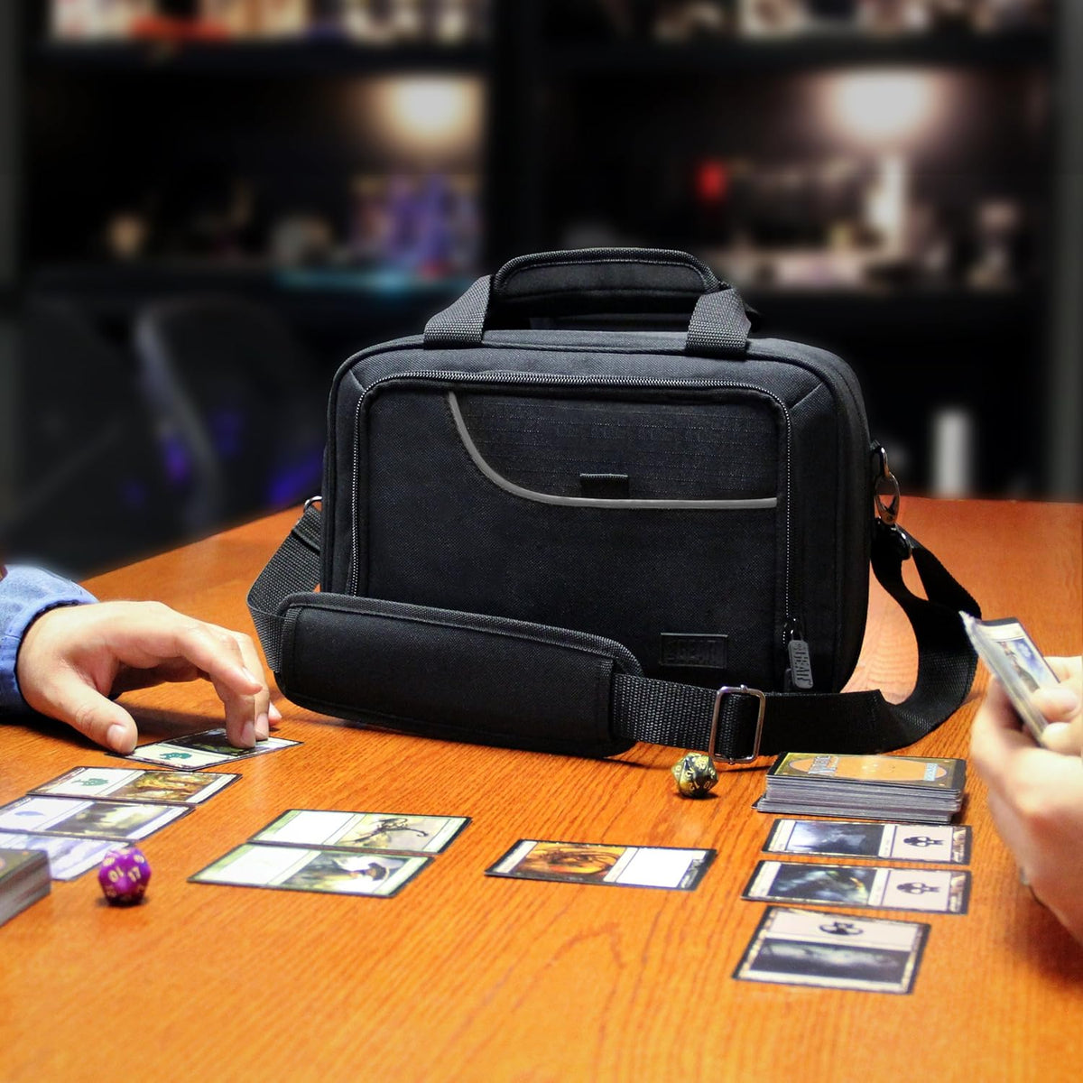 Black game bag on a wooden table; two players play a card game with cards and dice