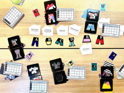 Colorful clothing game pieces, theme cards, and scorecards from a fashion board game spread on a wooden table