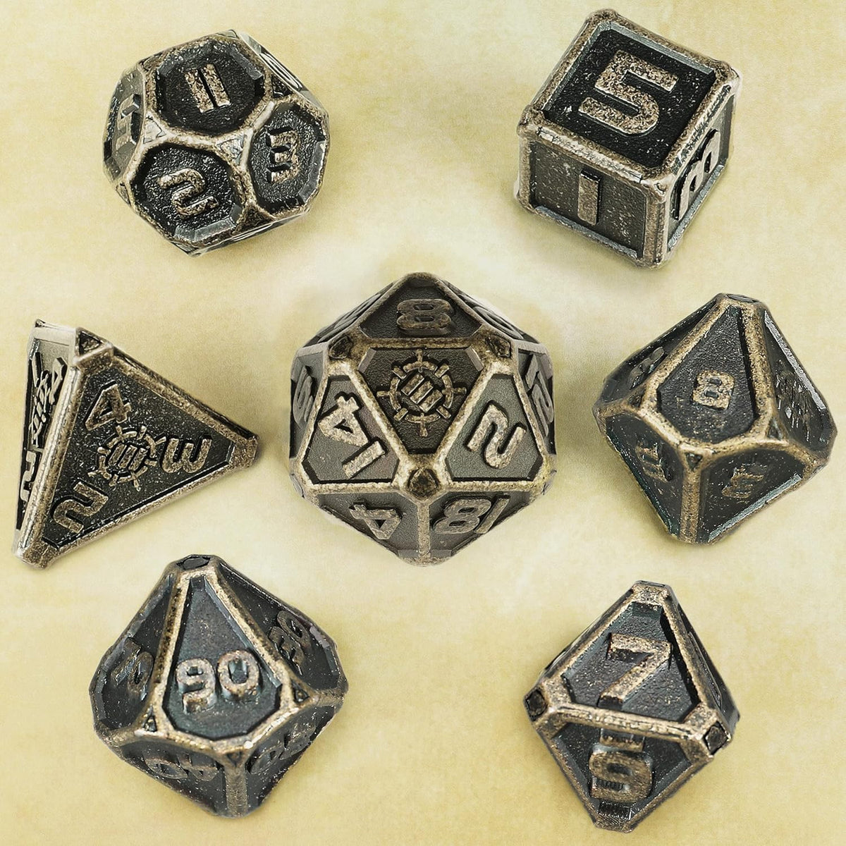 A set of 7 dark metal polyhedral dice for TTRPGs, scattered on a light textured surface