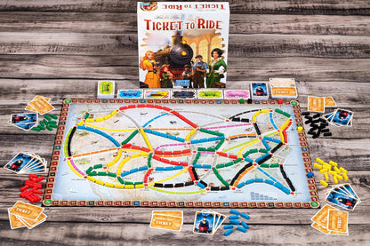 Ticket to Ride board game setup, showing the map filled with colorful train pieces, ticket cards, and the box