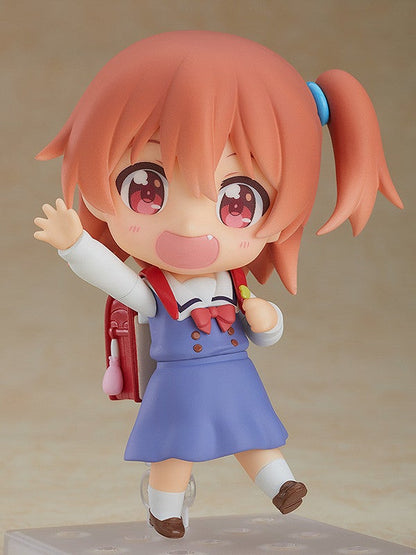 Nendoroid of a girl with pink hair and red eyes wearing a blue dress with a backpack waving on color background