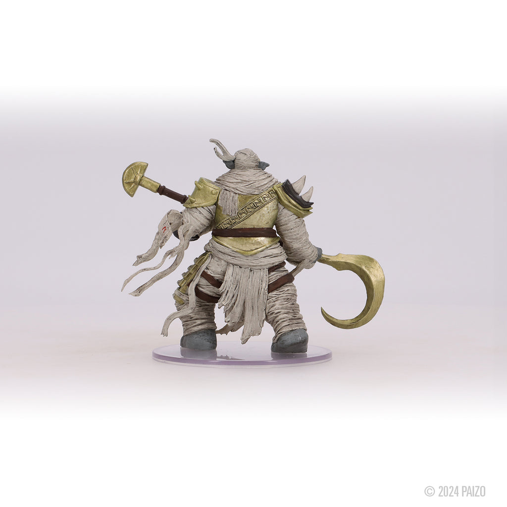 Heavily bandaged fantasy miniature with gold armor, holding a mace and a curved scythe, viewed from the back