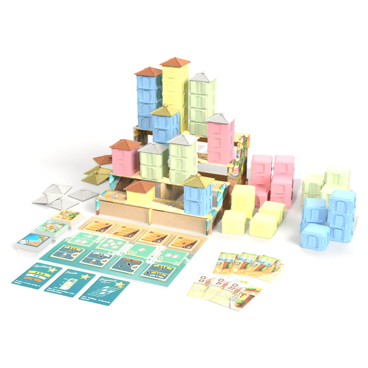 Complete set of the Positano city-building game showing pastel plastic houses assembled on a tiered platform with game cards and cardboard tiles scattered nearby