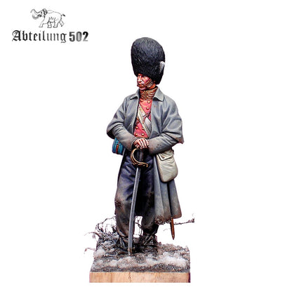 A Grenadier Guard Inkerman 1854 Figure, a detailed model soldier in a tall furry hat, long coat, and holding a sword, standing on a snowy base