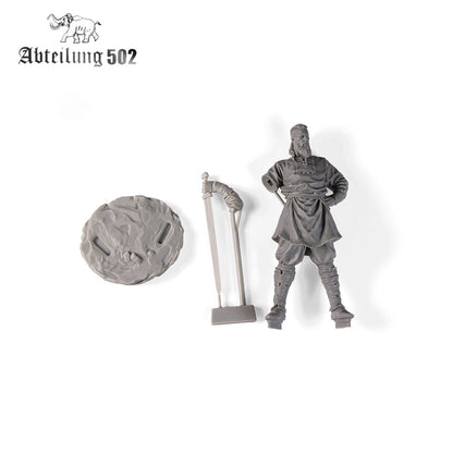 A gray resin model kit showing a bearded man, a textured base, and a separate staff accessory on a white background
