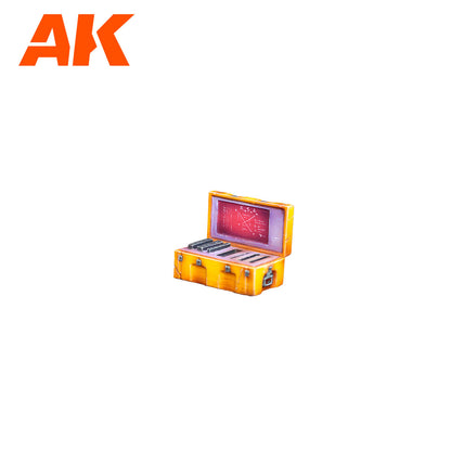 AK logo above an open orange sci-fi box. Red screen displays diagrams; compartments hold dark components