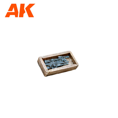 AK: Miniature dark gray rifles piled in a small wooden crate