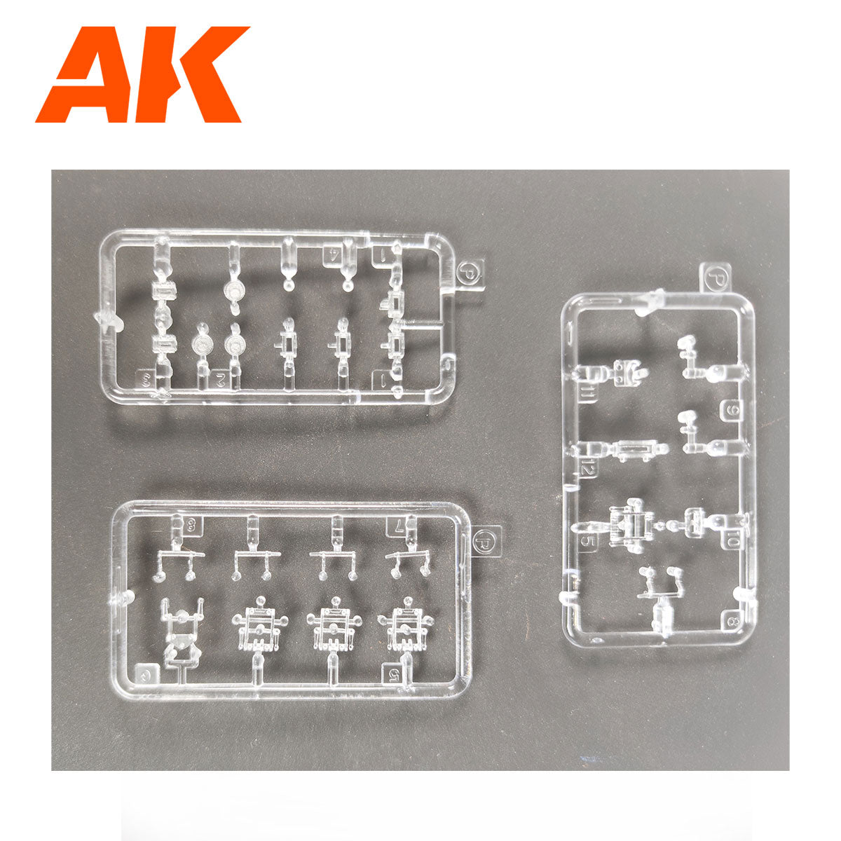 Three clear plastic model kit sprues with intricate parts are on a dark background