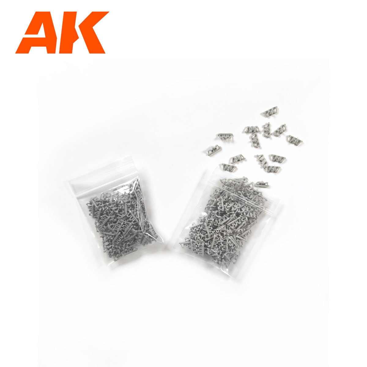 Two bags of small gray plastic model track links -  some spilled onto a white background