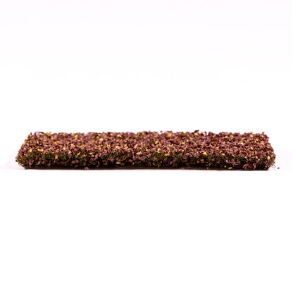 A rectangular mat of model ground cover with dense reddish-brown and yellow flakes