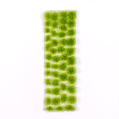 AK Interactive Vegetation Light Green Tufts 4mm are presented as numerous fuzzy, circular light green clusters arranged on a clear rectangular strip against a white background