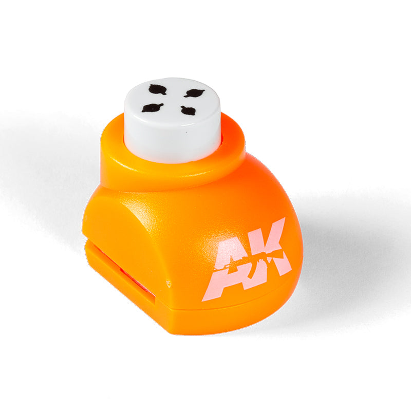 Orange craft punch with a white plunger showing four black leaf shapes, and an AK logo
