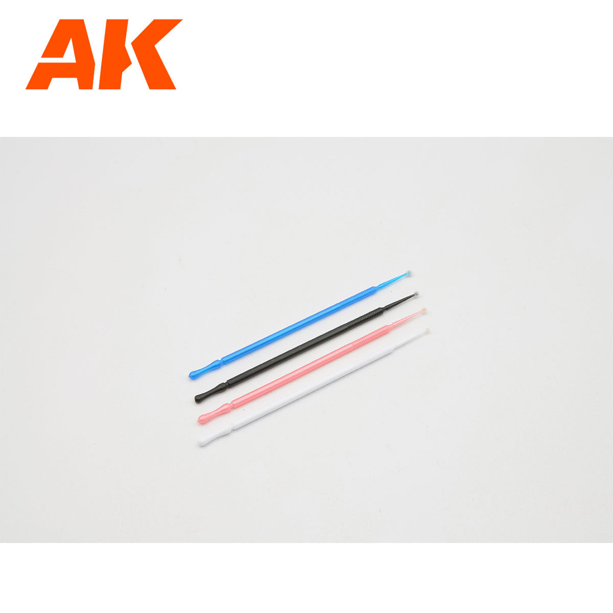 Four colorful AK Interactive micro applicators: blue, black, pink, and white, on a white background