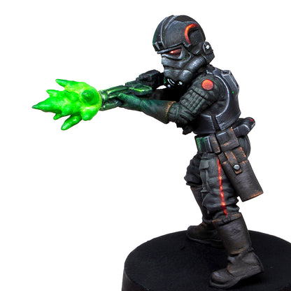 Sci-fi miniature in black tactical armor and mask, firing a bright green plasma energy bolt