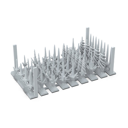 Unpainted resin miniature spikes and swirling fantasy bits on a sprue for tabletop models or terrain