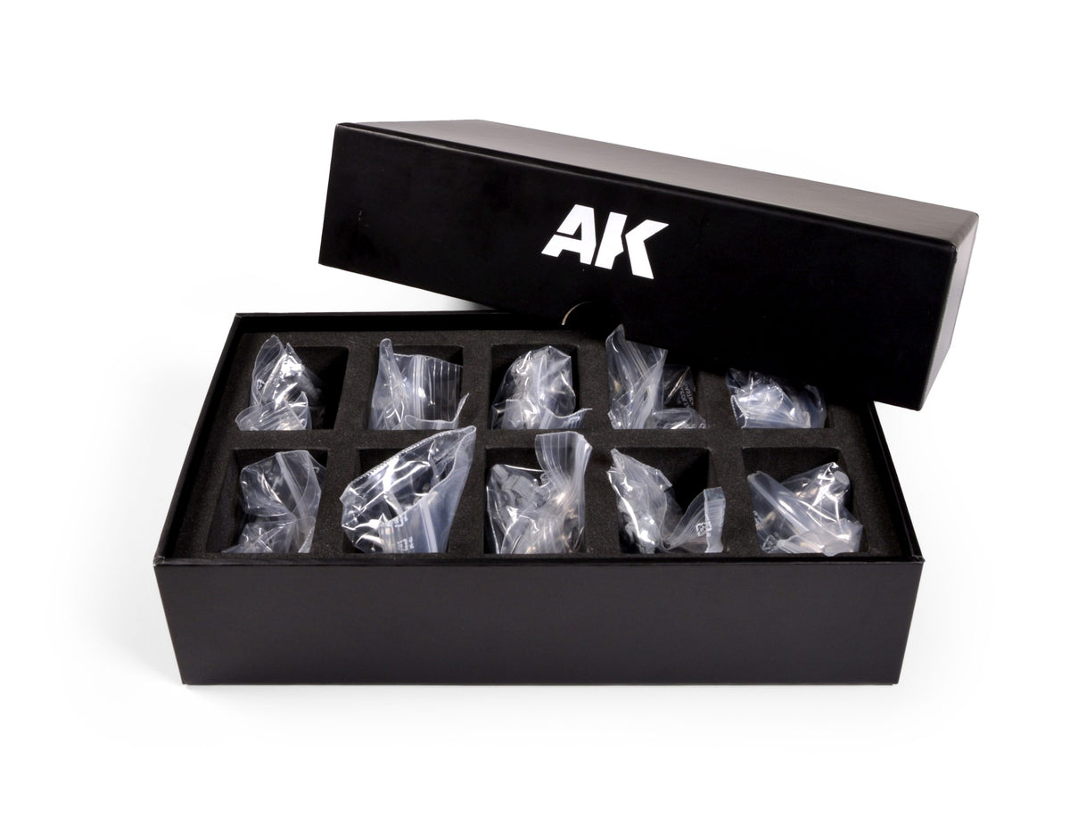 Open black box with AK logo containing small, bagged items in a foam insert