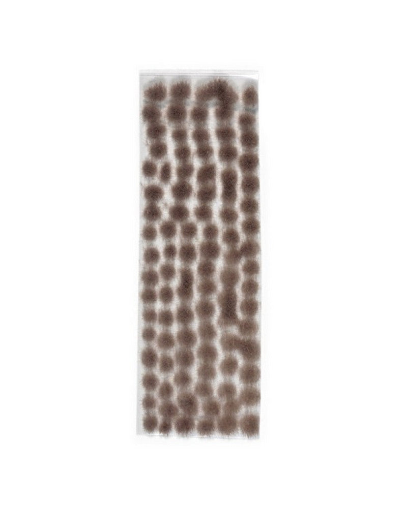 Brown-grey static grass tufts arranged on a clear sheet for model scenery
