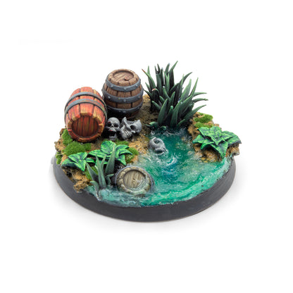 Miniature diorama base featuring barrels, skulls, tall grass, and a murky green swamp pond