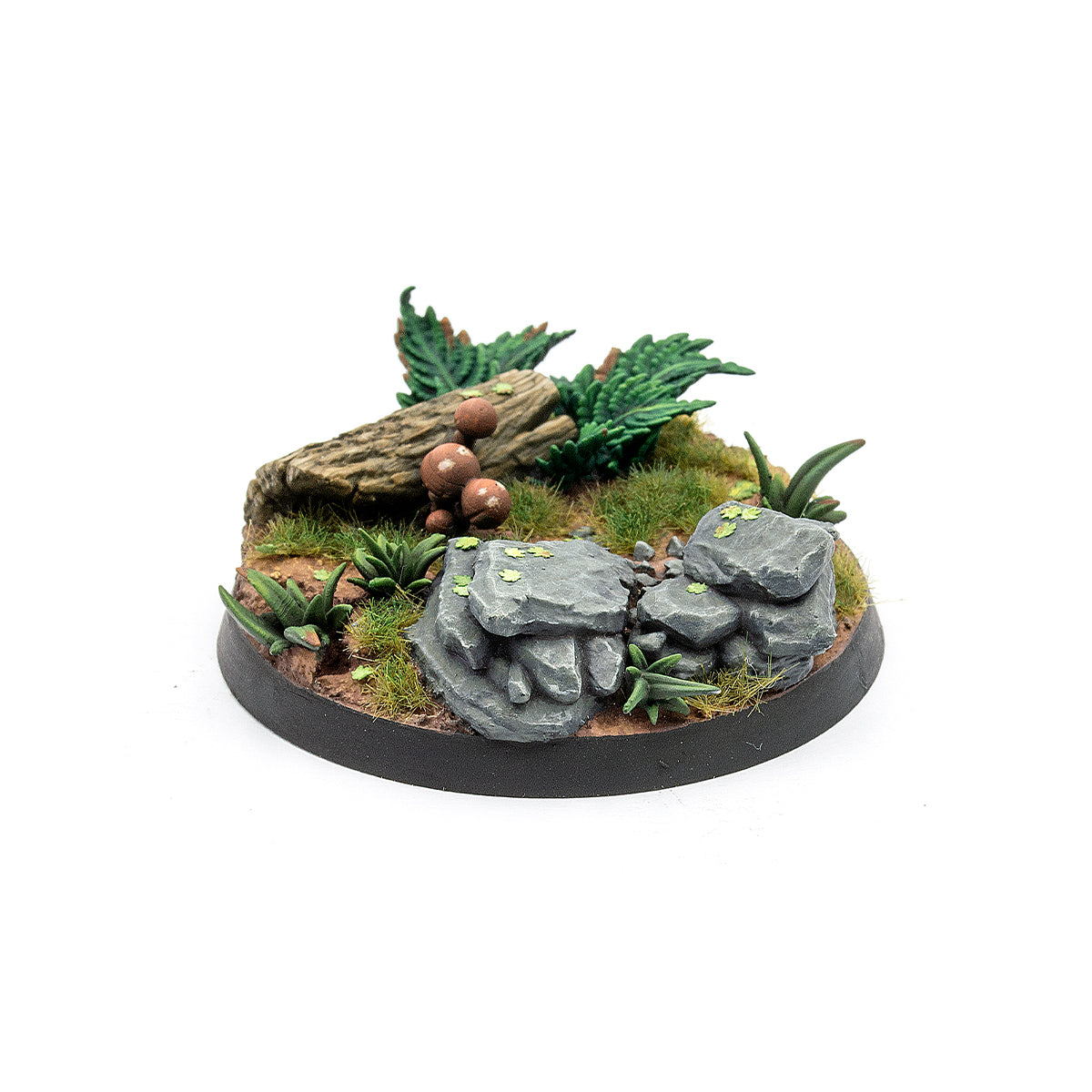 Detailed miniature base depicting forest terrain with rocks, a fallen log, mushrooms, and lush green foliage