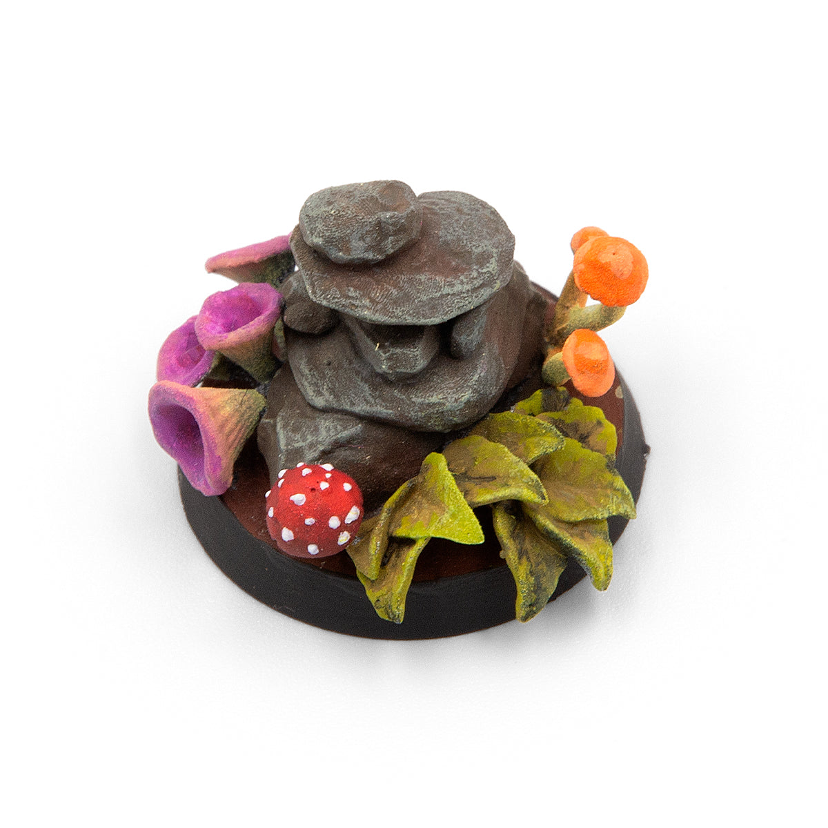 Miniature scenic base with a brown rock stack, colorful fantasy fungi (pink, orange, red), and green foliage