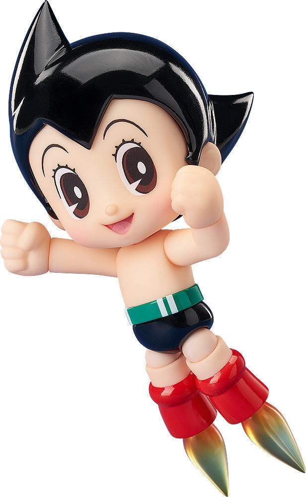 Astro Boy figurine flying, smiling, fists clenched, wearing blue shorts and red rocket boots with fiery thrust