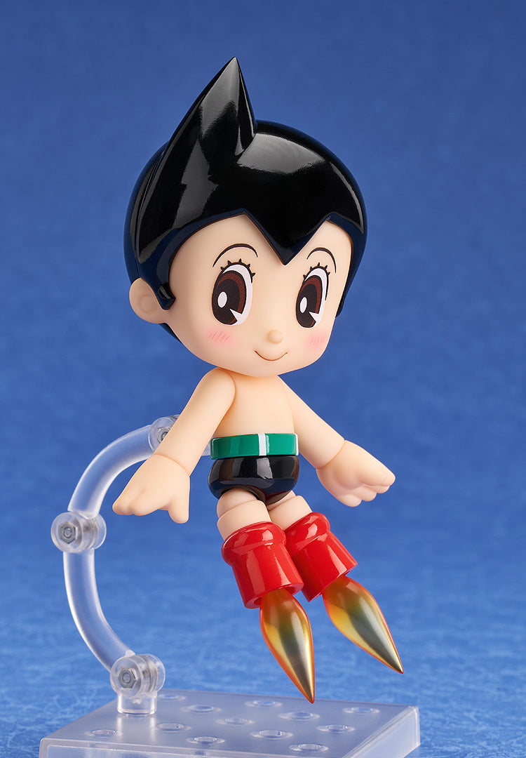 Astro Boy figure hovering, red rocket boots with golden flames, against a blue background