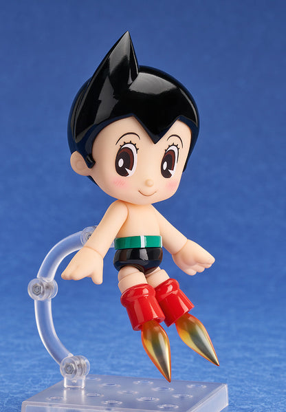 Astro Boy figure hovering, red rocket boots with golden flames, against a blue background