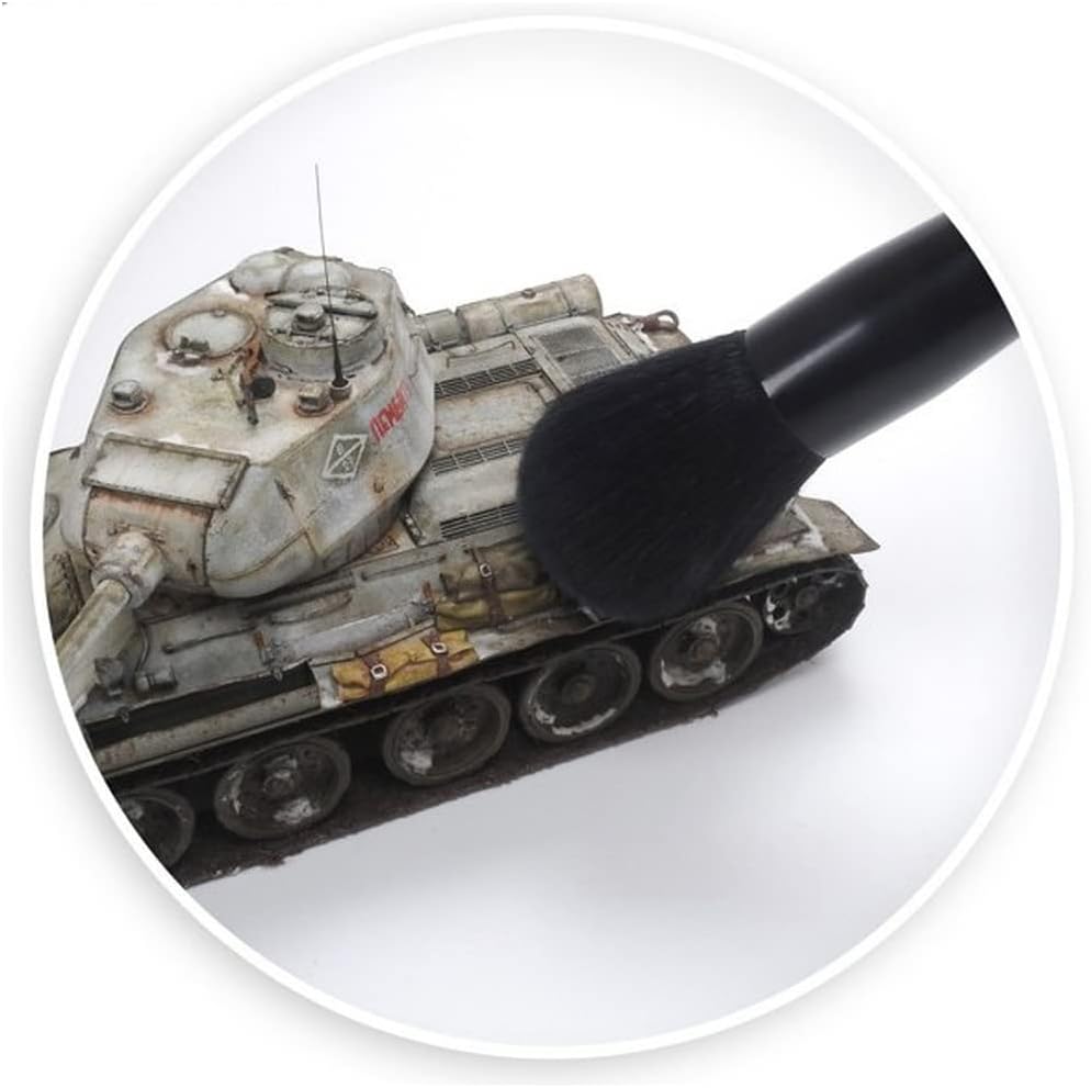 A soft black brush is used on a detailed, weathered grey model tank for cleaning or applying effects.