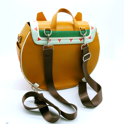 A golden-brown rounded backpack with a mint green flap, red & white triangles, and brown shoulder straps.