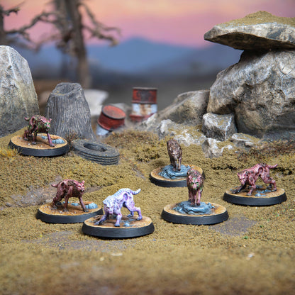 Six mutated, dog-like miniatures, some with green glowing parts, crouch menacingly on a rocky wasteland with barrels