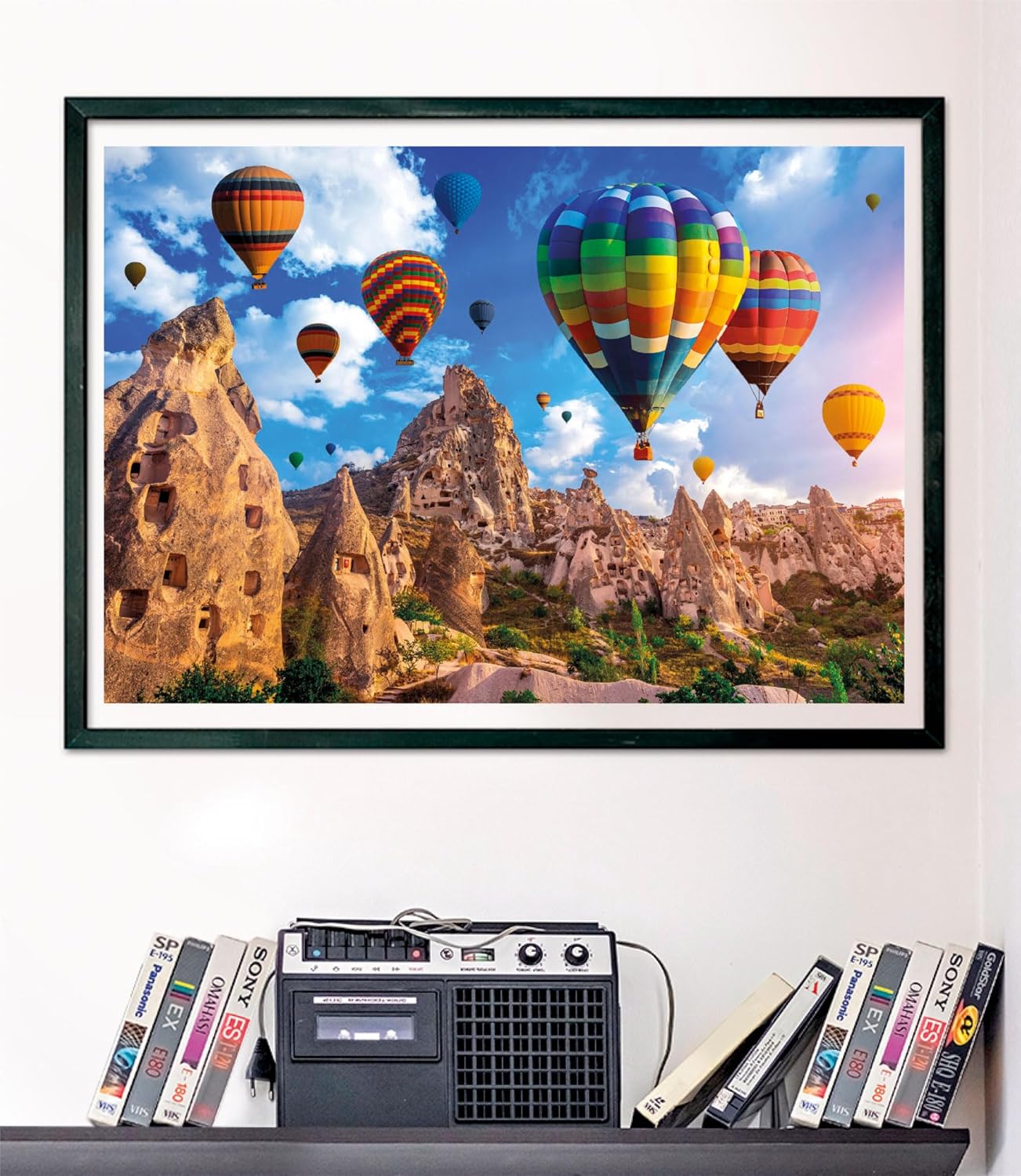 A framed picture shows colorful hot air balloons flying over unique rocky landscapes and ancient cave dwellings.