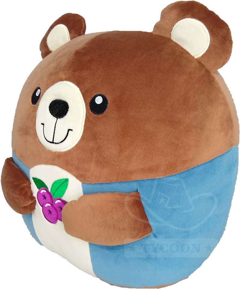 A round brown plush bear wearing a blue outfit, holding embroidered purple blueberries.