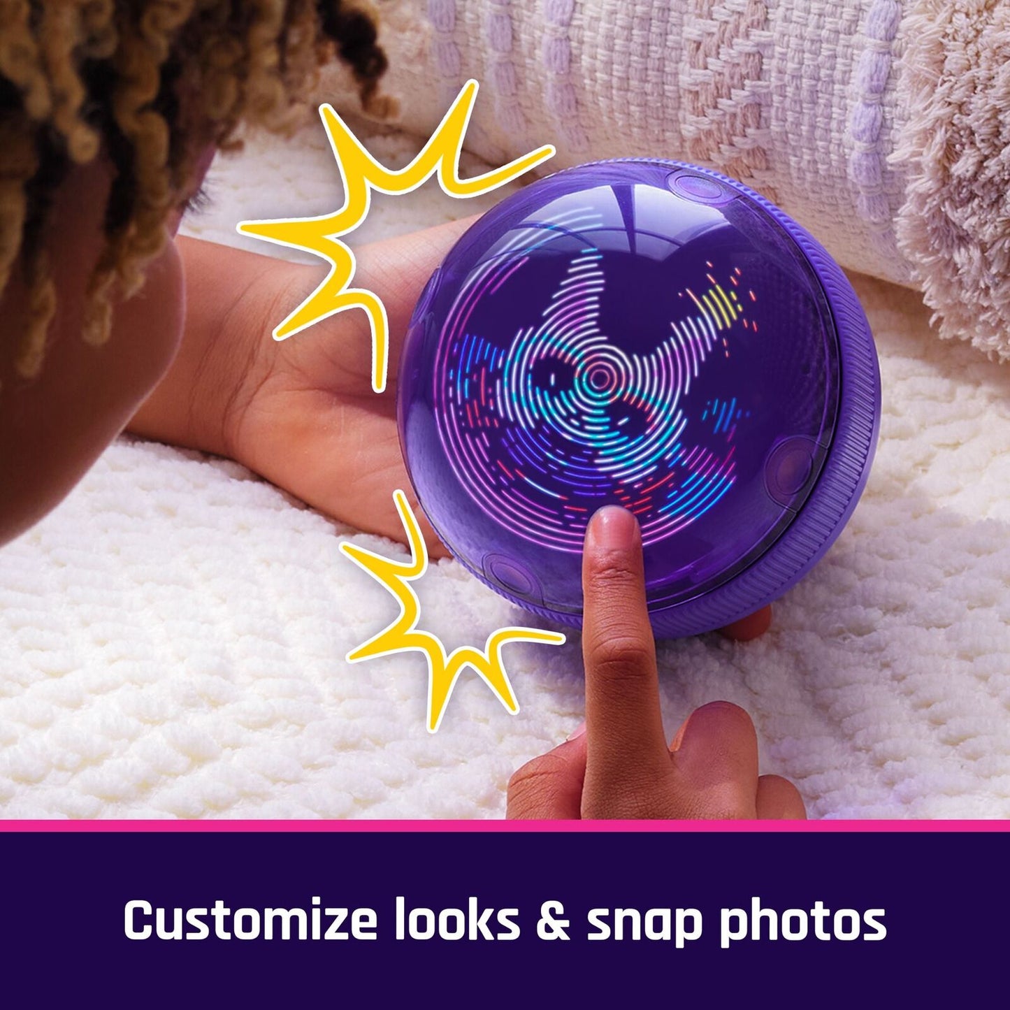 Child's hand touching a purple electronic orb with vibrant swirling lights, resting on a soft white blanket