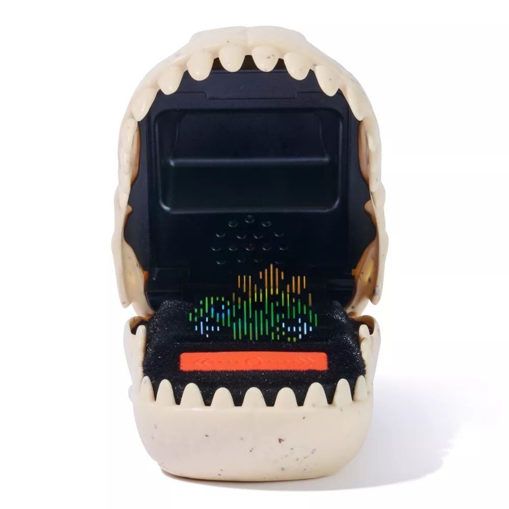 Opened beige dinosaur jaw-shaped device reveals a colorful equalizer display and an orange button against a black interior