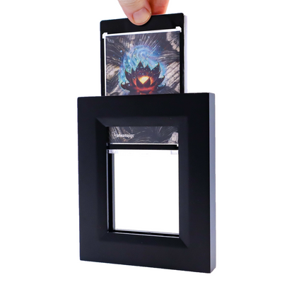 Hand inserts a card featuring a glowing lotus into a black Frameamajigs frame