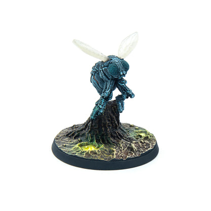 Miniature of a dark blue insect creature with large compound eyes and translucent wings, standing on a swampy base with glowing green puddles