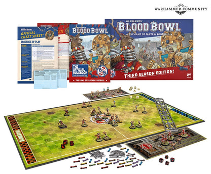 Blood Bowl Third Season Edition game set spread out, showing the playing field, fantasy miniatures, rulebook and dice