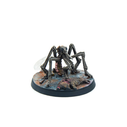 A detailed miniature of a grey mosquito-like creature with translucent wings and a pink abdomen, standing on a dark, gore-splattered base
