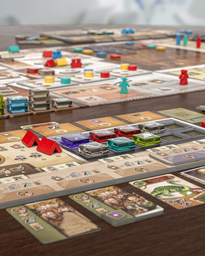 A vibrant board game setup with colorful meeples, resource cubes, and dinosaur cards on a wooden table