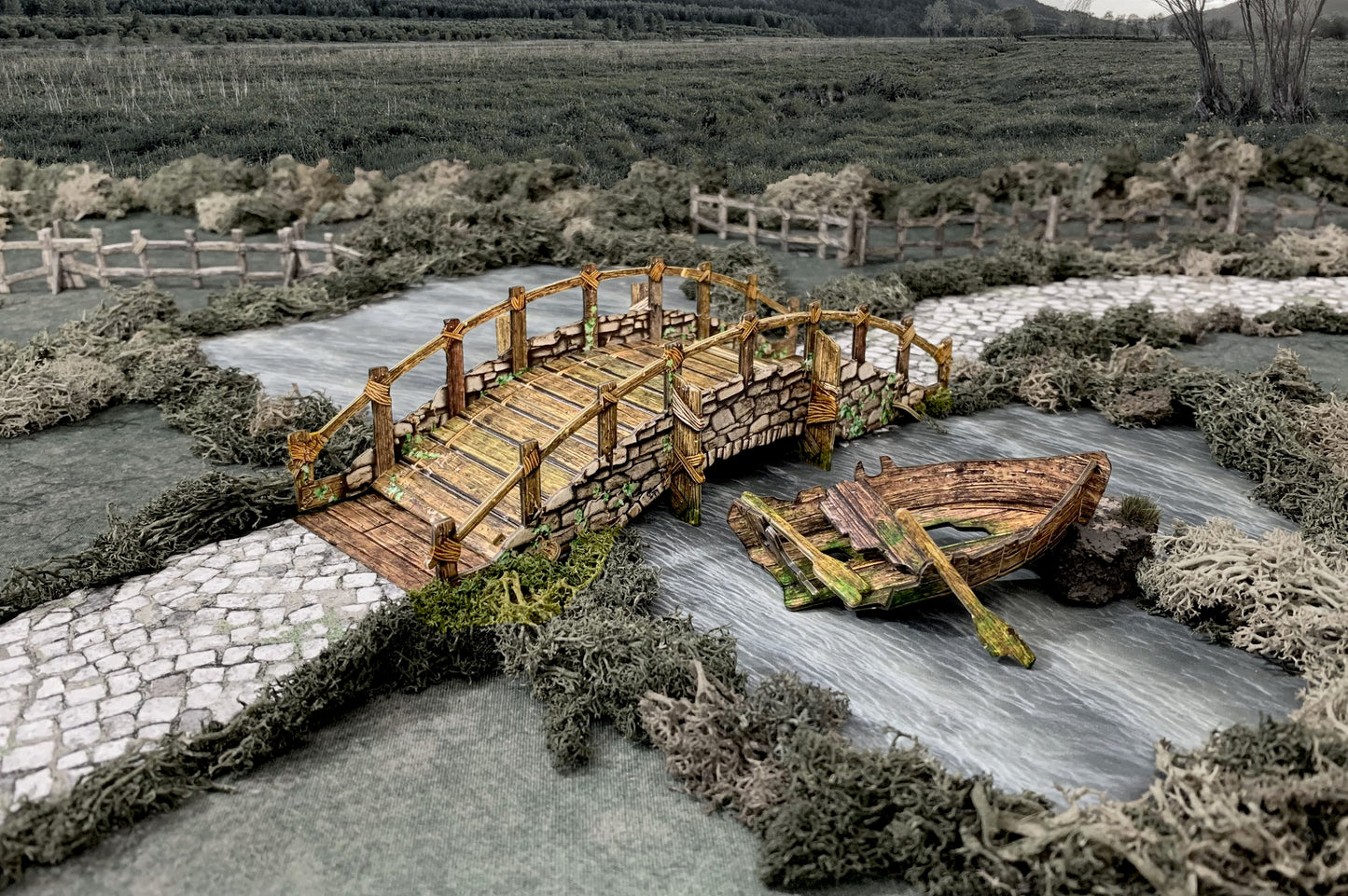 A miniature scene: Rustic stone bridge over a river with a broken boat and oar floating next to it. Cobblestone path.