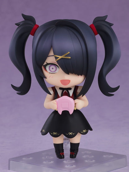 Smiling Nendoroid figure with black pigtails, gold X barrette, purple eyes, black dress, holding a pink controller