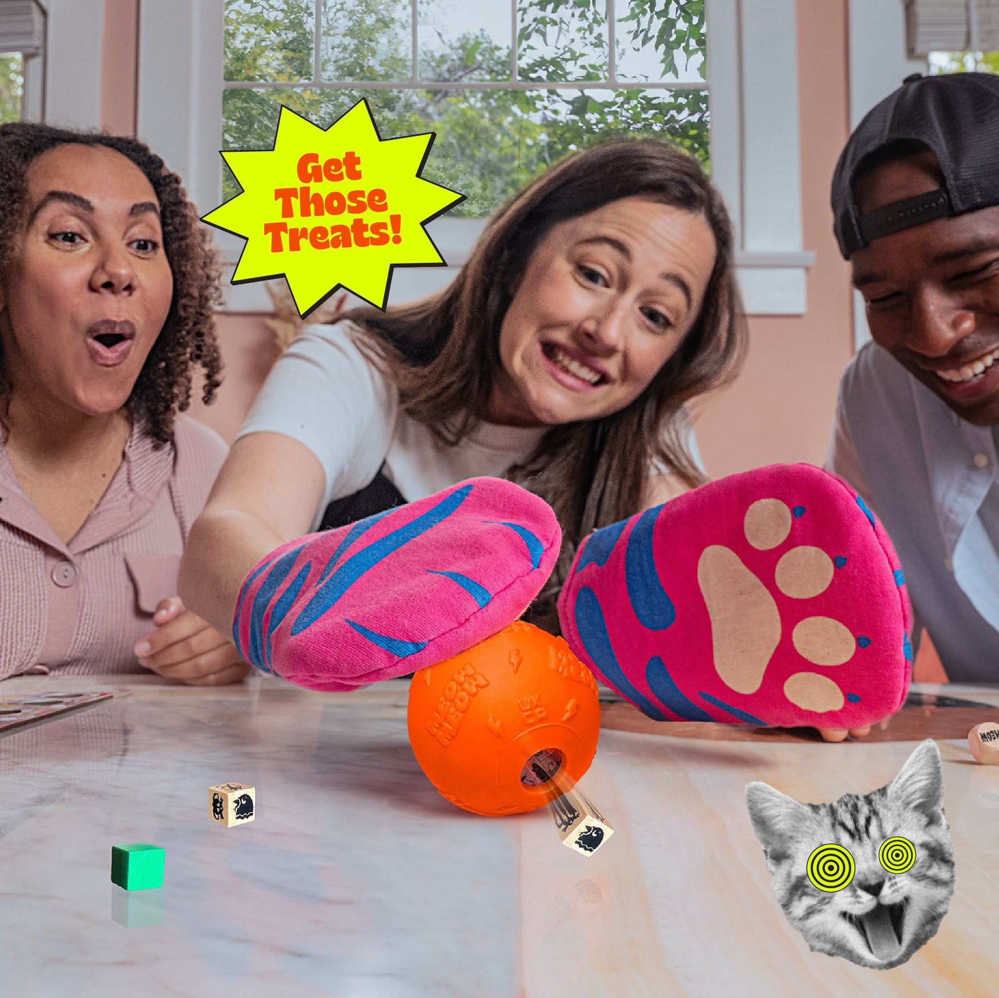 A woman in pink cat paw gloves plays "Get Those Treats" reaching for an orange ball as a dice shoots out watched by friends