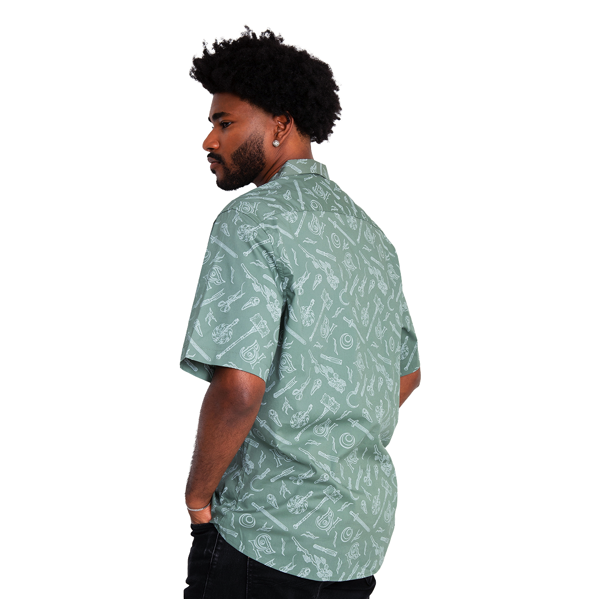A man in a green short-sleeve shirt with white weapon patterns looking over his left shoulder, hands in pockets