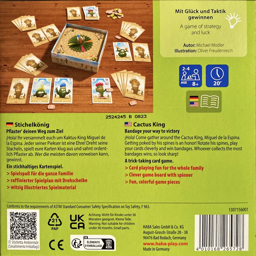 Colourful "Cactus King" board game components, including a spinner board, cartoon cactus cards, and tokens, on wood.