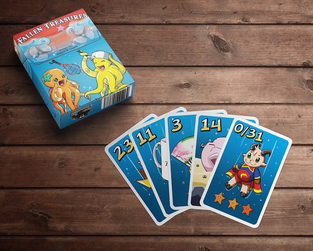 Fallen Treasures card game box with cartoon octopuses and fanned blue cards showing numbers and a superhero goat on wood.