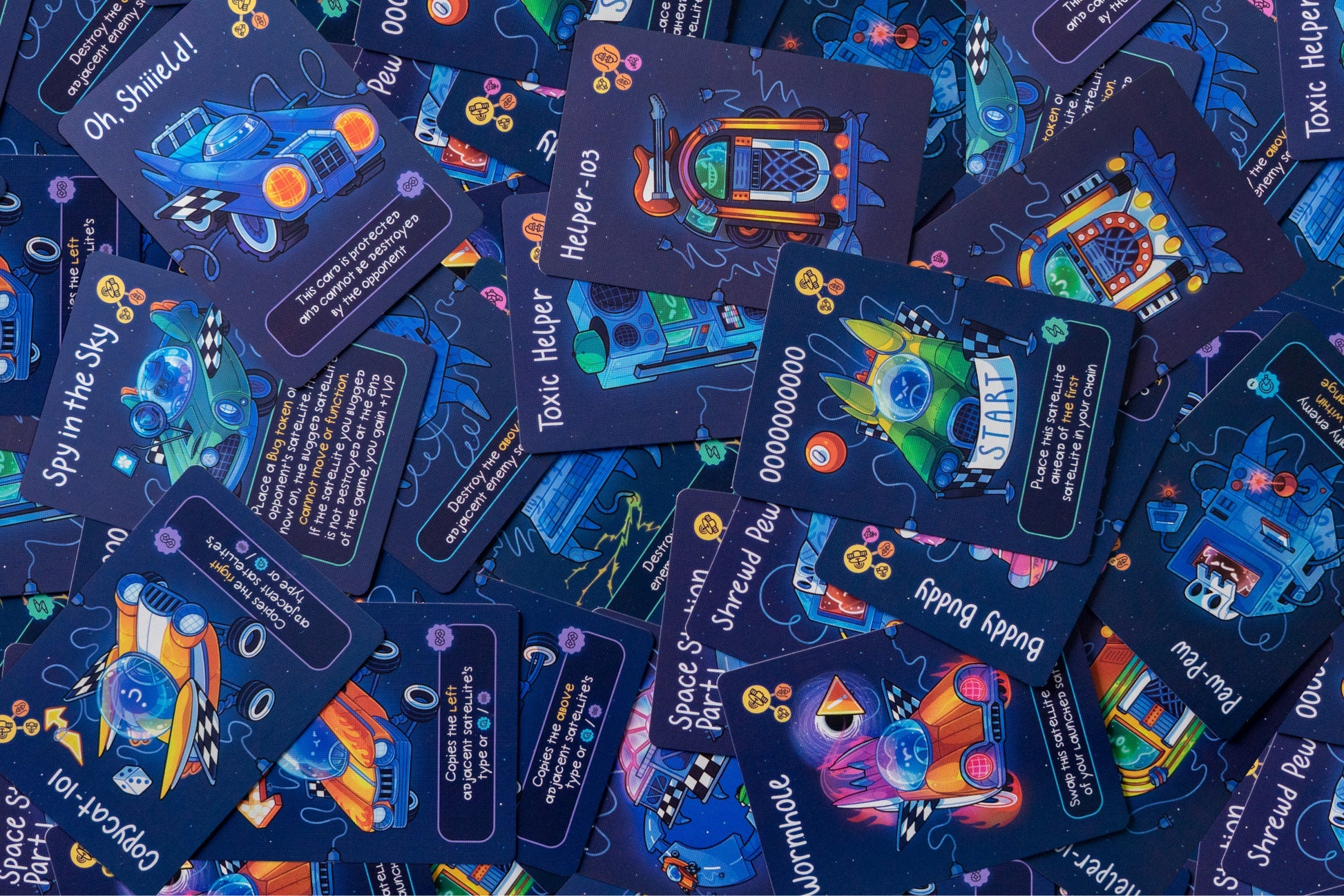 A pile of vibrant, sci-fi themed game cards, depicting space vehicles and robots, spread across a table