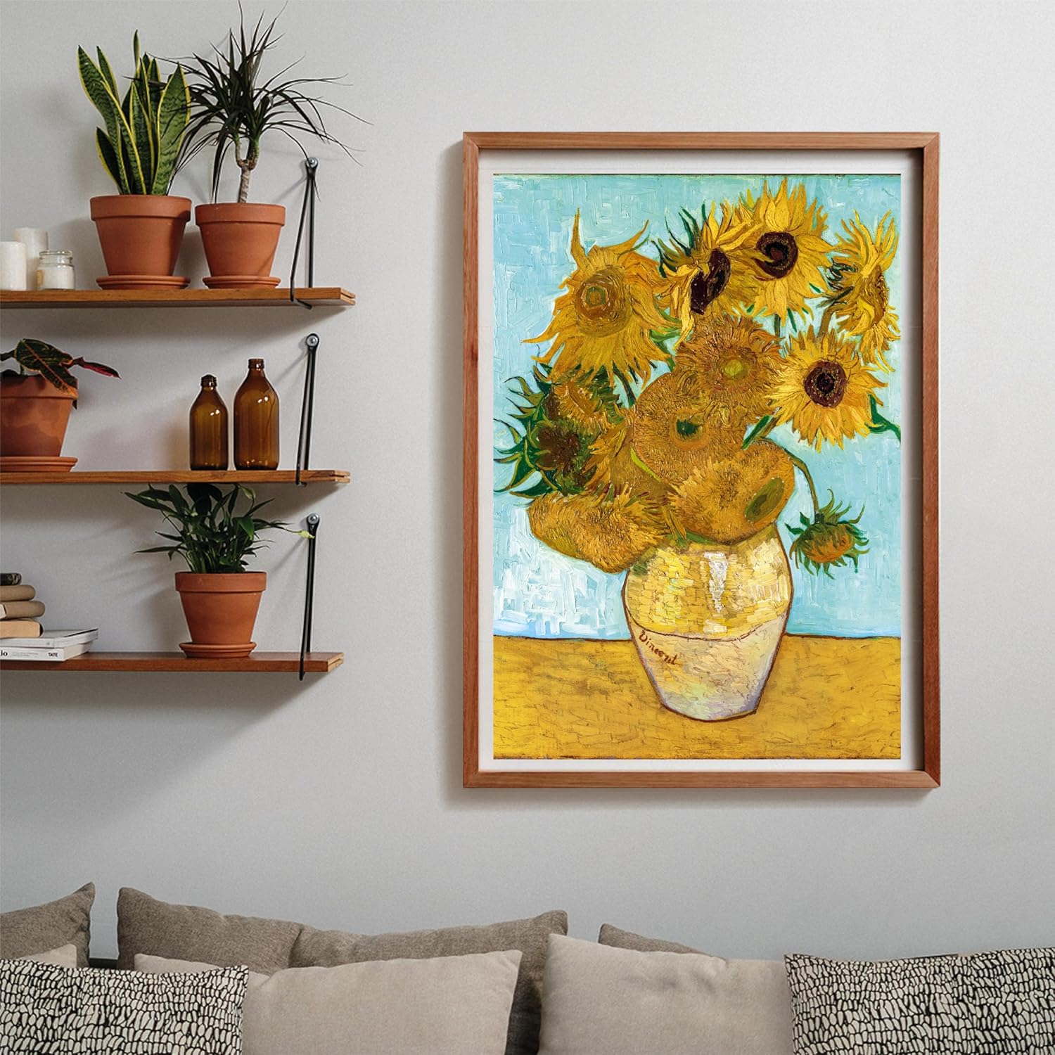 A framed Van Gogh's Sunflowers painting hangs on a white wall above a sofa, next to shelves with potted plants