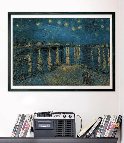 A framed print of Van Gogh's Starry Night Over the Rhone hangs above a shelf with a cassette player and stacked VHS tapes
