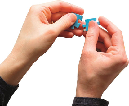 Close-up of hands fitting two blue puzzle pieces